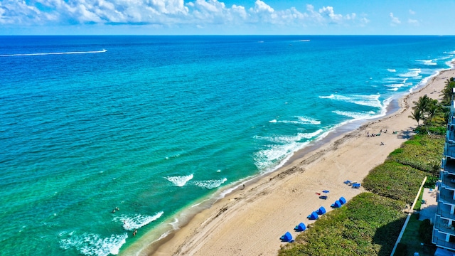 birds eye view of property with a water view and a beach view