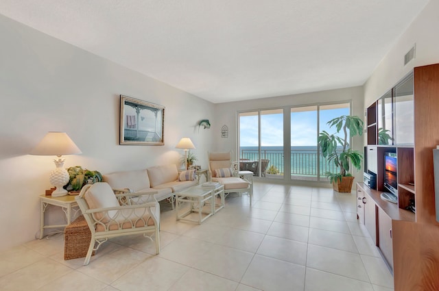 living room featuring a water view and light tile flooring