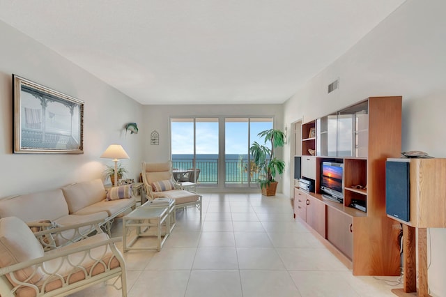 living room featuring a water view and light tile floors