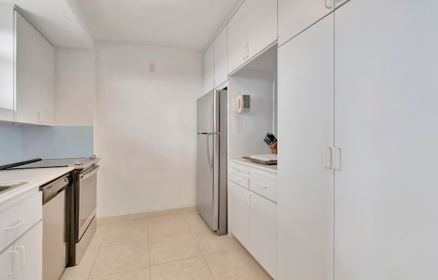 kitchen featuring stainless steel appliances, white cabinetry, and light tile floors