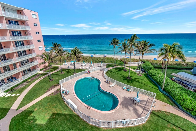 view of swimming pool featuring a lawn and a water view