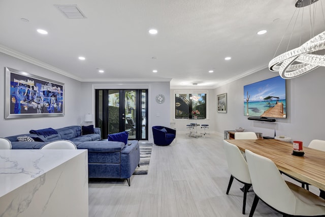 living room featuring light hardwood / wood-style flooring, french doors, and crown molding