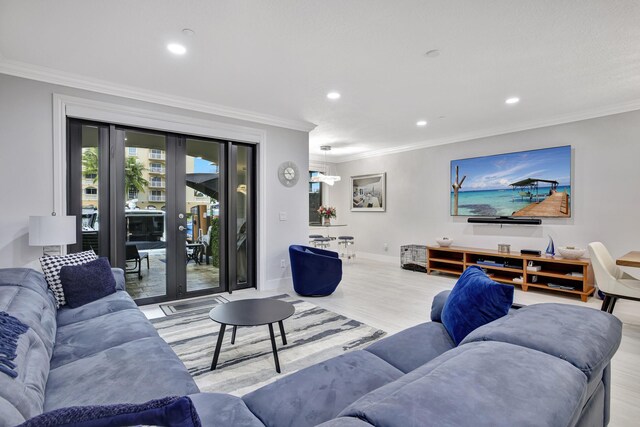 living room with french doors, light wood-type flooring, and ornamental molding