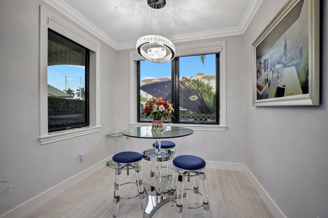 dining room featuring light wood-type flooring, crown molding, and a chandelier