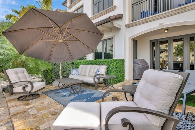 view of patio with outdoor lounge area, grilling area, a balcony, and french doors