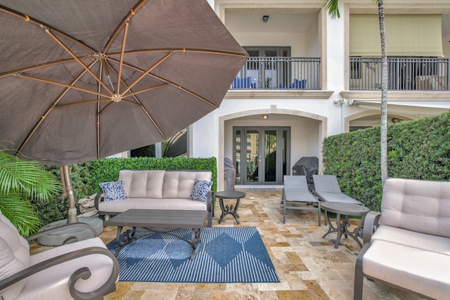 view of patio with french doors, a balcony, and an outdoor living space