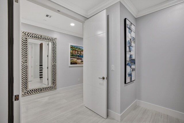 hallway with light wood-type flooring and ornamental molding