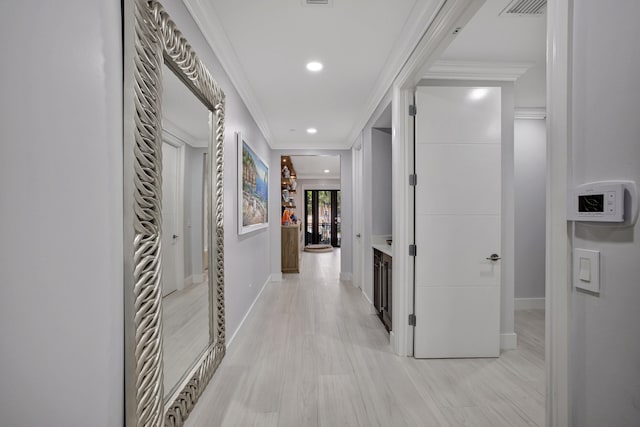 corridor with light hardwood / wood-style flooring and crown molding