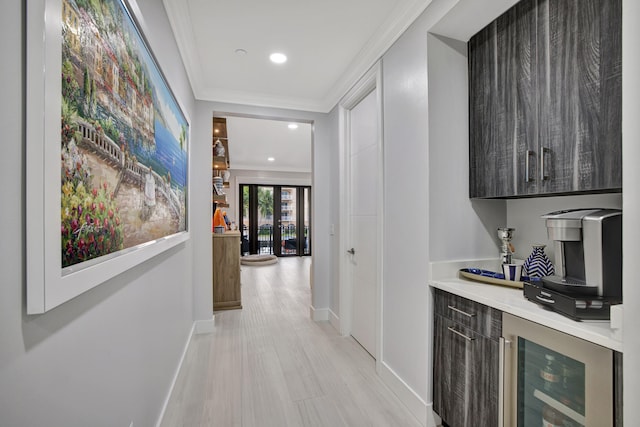 bar featuring wine cooler, light hardwood / wood-style flooring, and ornamental molding