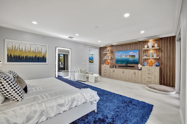 bedroom with wooden walls, ornamental molding, and hardwood / wood-style floors