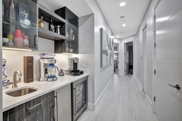 kitchen featuring light hardwood / wood-style floors, sink, and wine cooler