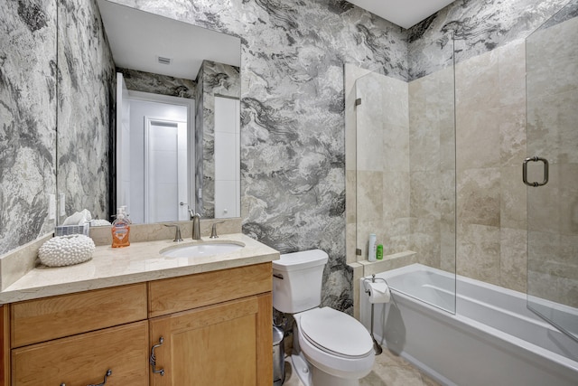 full bathroom with combined bath / shower with glass door, vanity, and toilet