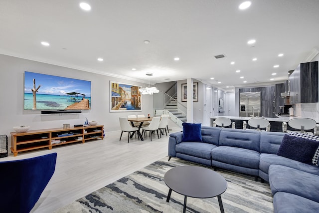 living room featuring crown molding, light hardwood / wood-style floors, and a chandelier