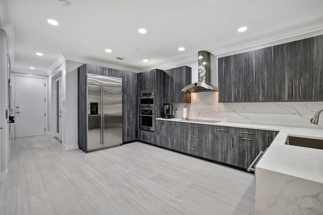 kitchen with sink, wall chimney exhaust hood, stainless steel appliances, decorative backsplash, and ornamental molding