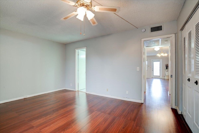 spare room with ceiling fan with notable chandelier, a textured ceiling, and hardwood / wood-style flooring