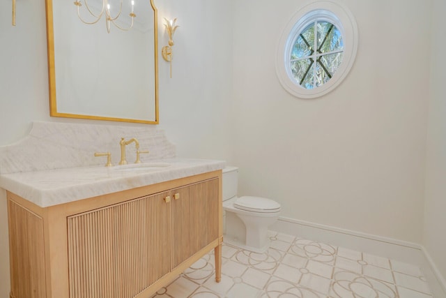 bathroom featuring tile floors, toilet, vanity, and a chandelier