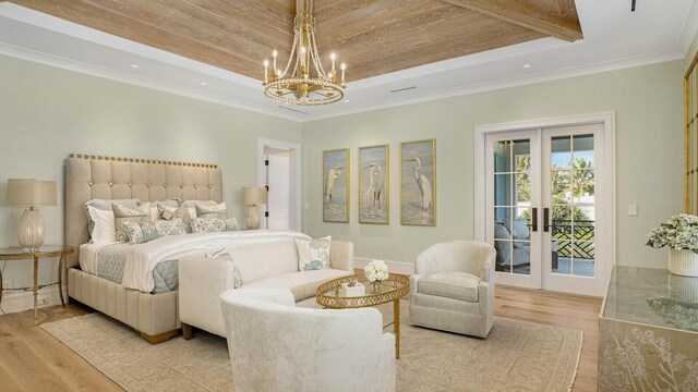 unfurnished room featuring crown molding, a raised ceiling, light hardwood / wood-style floors, and an inviting chandelier