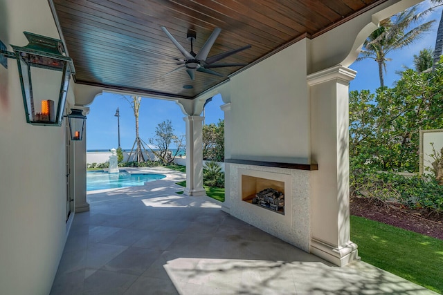 view of patio featuring exterior fireplace and ceiling fan