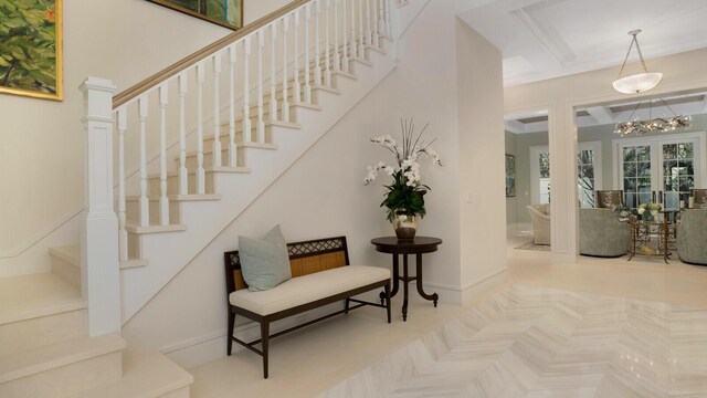 empty room featuring built in features, a notable chandelier, light wood-type flooring, and crown molding