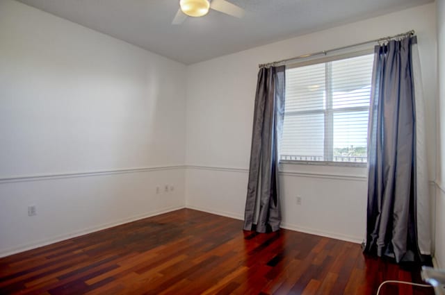 unfurnished room with dark hardwood / wood-style flooring and ceiling fan