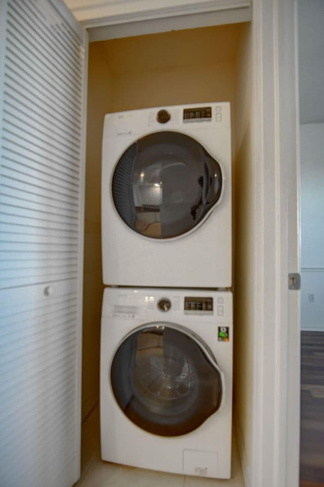 laundry area featuring stacked washer and dryer and light wood-type flooring