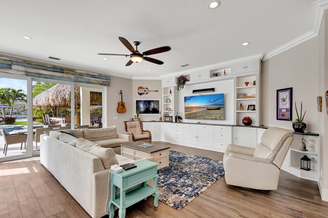 living room with wood-type flooring, ceiling fan, ornamental molding, and built in features