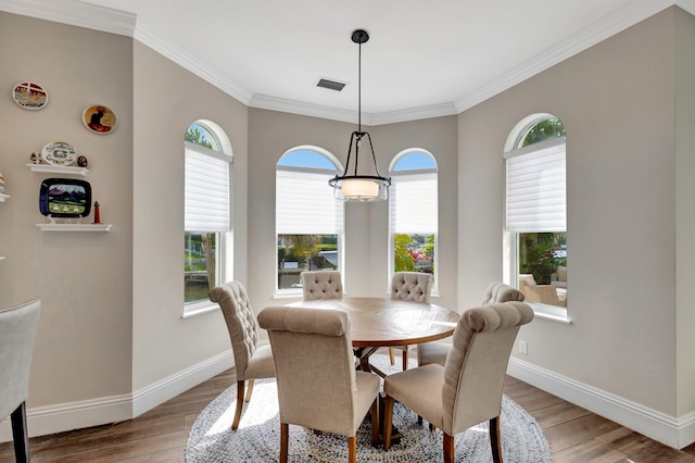 dining room with light hardwood / wood-style floors and crown molding