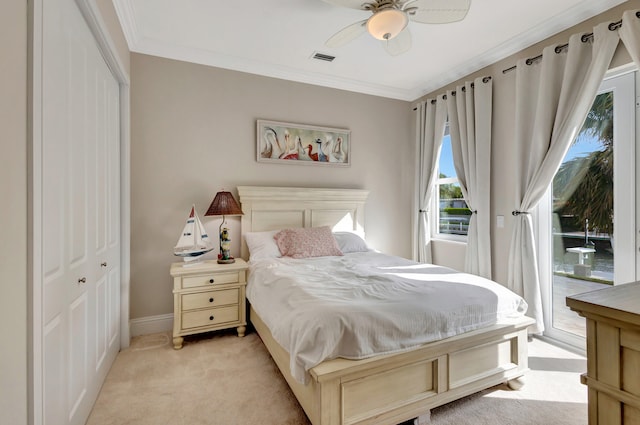 carpeted bedroom featuring access to exterior, a closet, ceiling fan, and crown molding