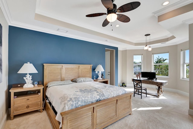 carpeted bedroom featuring ceiling fan, crown molding, and a raised ceiling