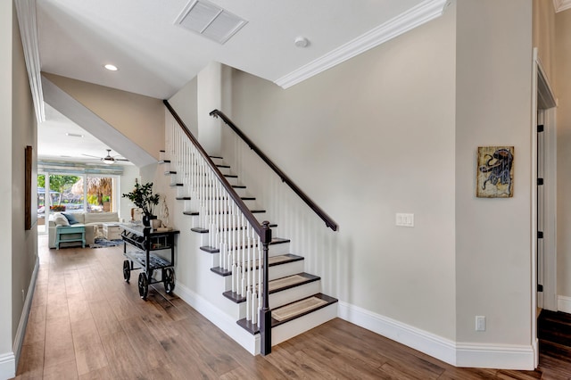 stairs featuring hardwood / wood-style flooring, ceiling fan, and crown molding