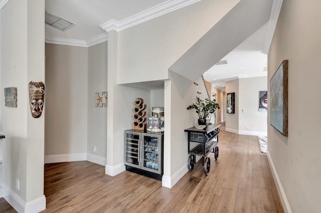 hallway featuring ornamental molding and light wood-type flooring