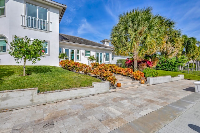 exterior space featuring a patio area and a front lawn