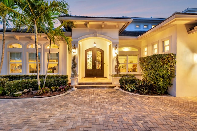 exterior entry at dusk featuring french doors