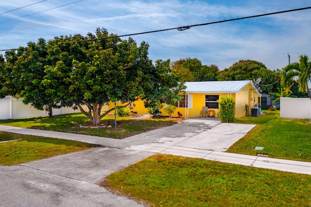 view of front of property featuring central AC unit and a front yard