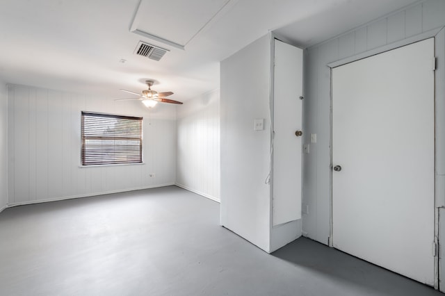 spare room with ceiling fan and concrete flooring