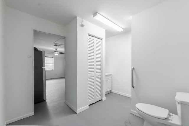 bathroom with toilet, vanity, ceiling fan, and concrete flooring