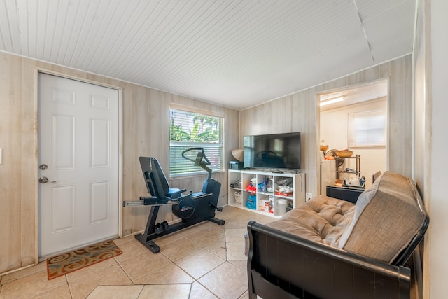 living room with lofted ceiling, wooden walls, and light tile floors