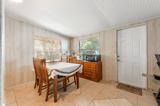 tiled dining space featuring wooden walls