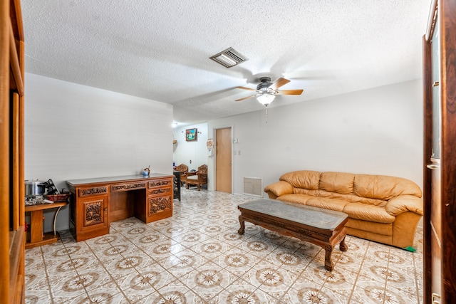 living room featuring a textured ceiling, ceiling fan, and light tile floors