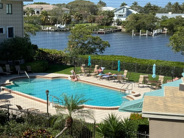 view of pool featuring a water view and a patio