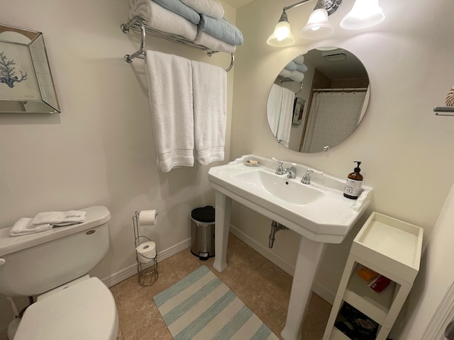 bathroom featuring a shower with shower curtain and toilet