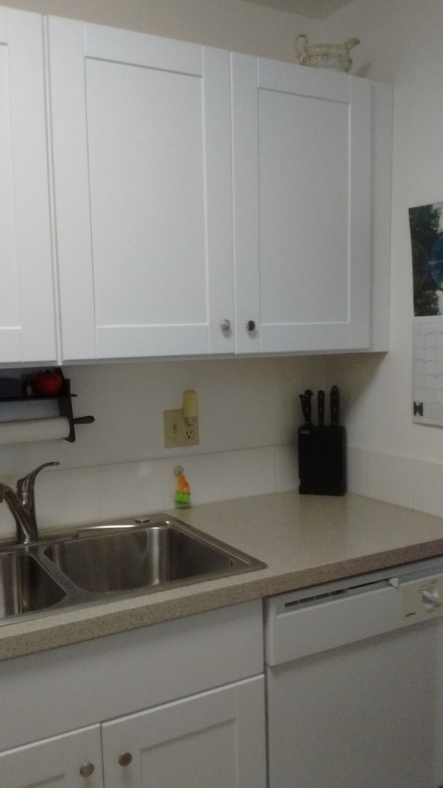 kitchen featuring white cabinets, dishwasher, and sink