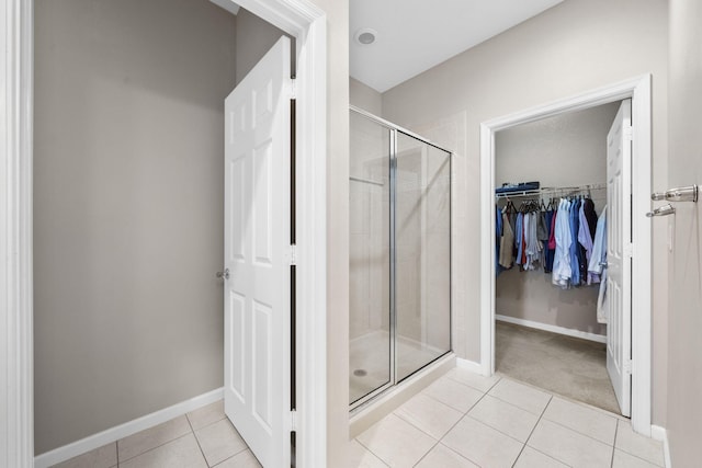 bathroom with tile flooring and a shower with shower door