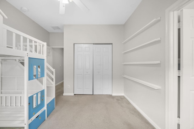 unfurnished bedroom featuring light carpet, a closet, and ceiling fan