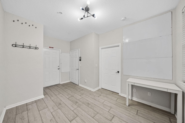 interior space with a textured ceiling and light hardwood / wood-style floors