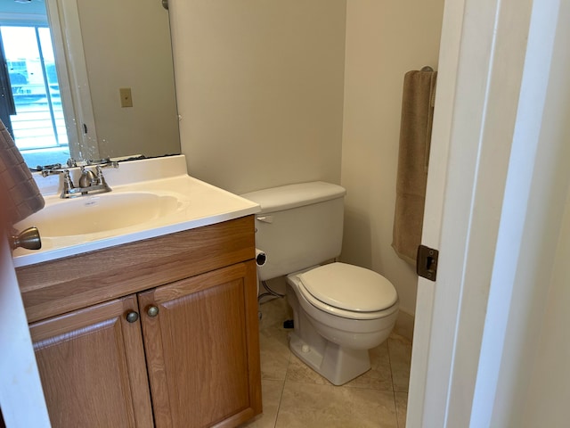 bathroom with toilet, vanity, and tile flooring