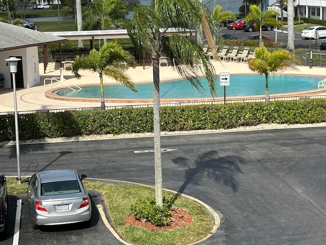 view of parking / parking lot with a community pool