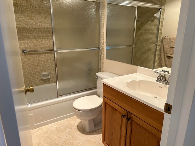 full bathroom with combined bath / shower with glass door, vanity, tile flooring, and toilet