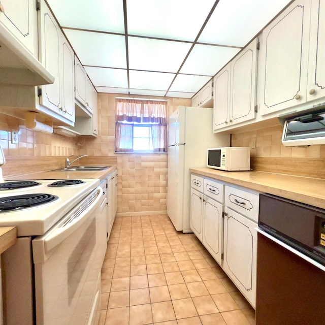 kitchen with white appliances, white cabinets, sink, and light tile floors