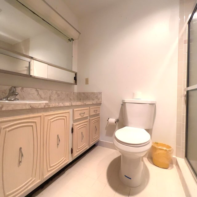 bathroom featuring tile floors, toilet, vanity, and an enclosed shower